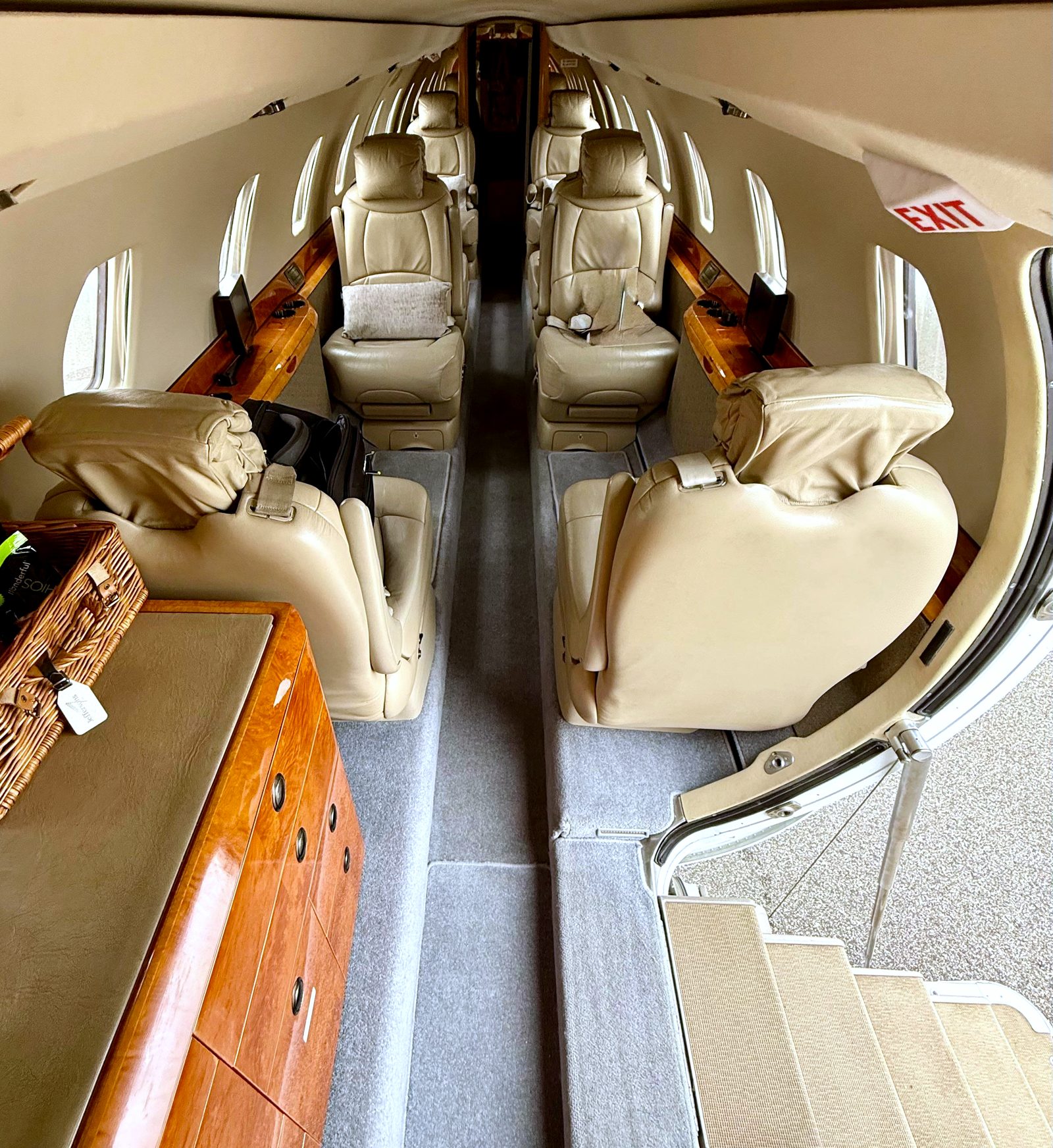 Citation X cabin looking aft from the entry door, double club seating and burr walnut cabinet