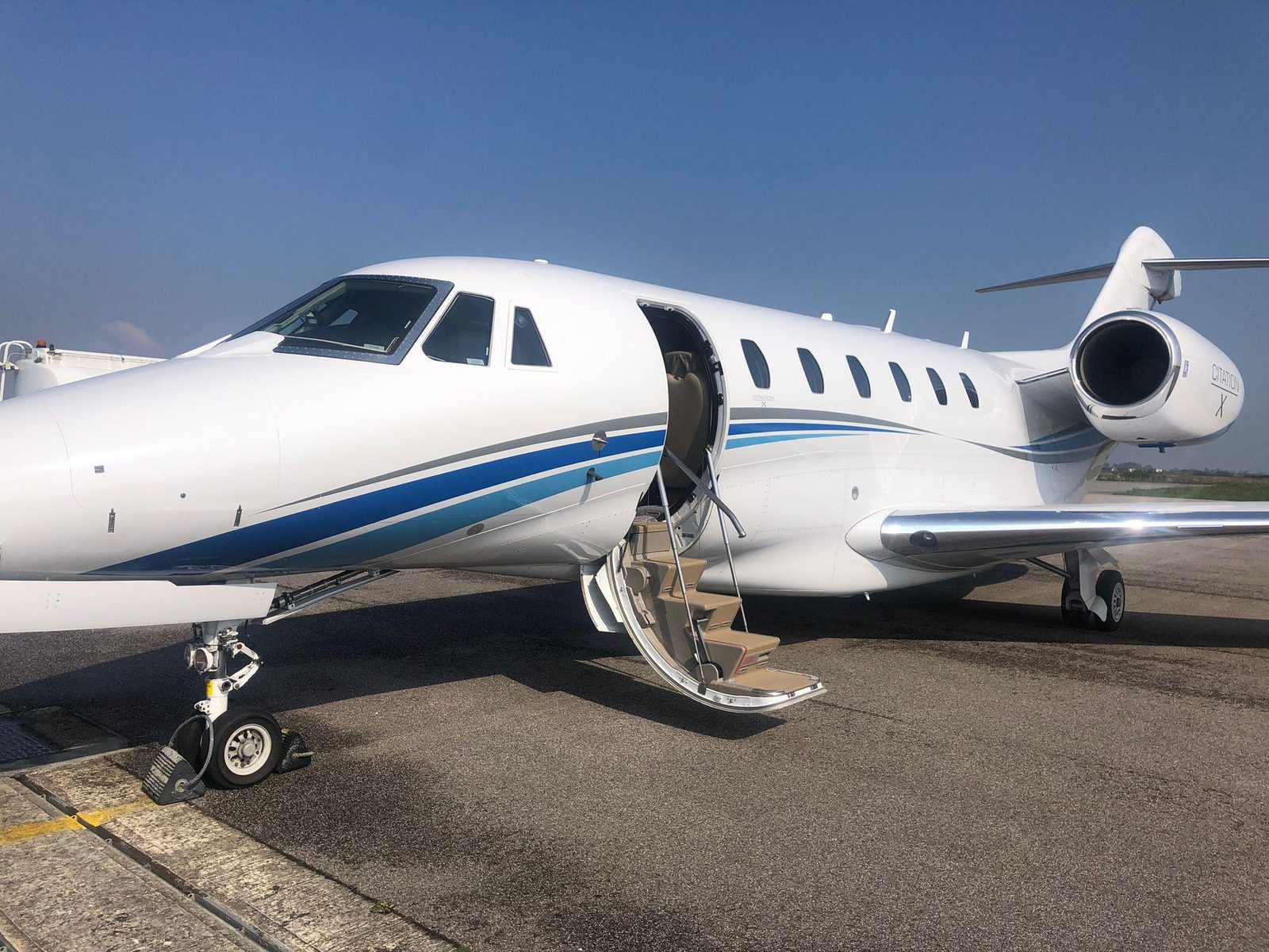 Cessna Citation X parked on the ramp with the airstair down under clear blue sky
