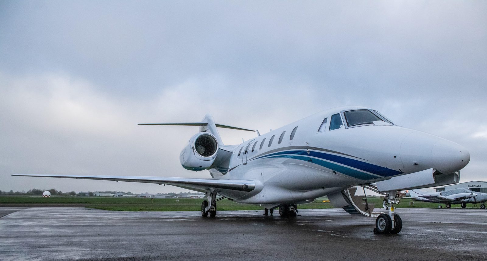 Cessna Citation X on a wet apron, three-quarter view from the front, overcast sky