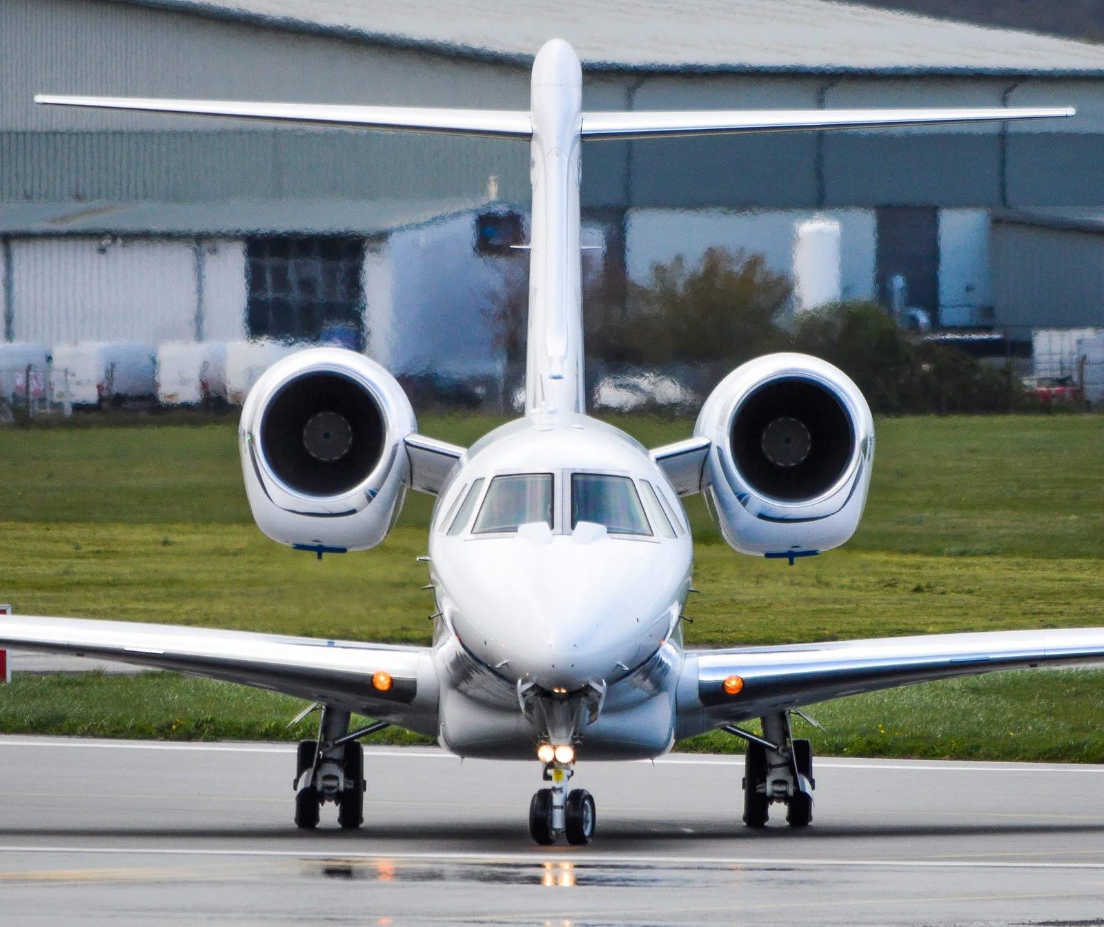 Cessna Citation X head on, taxiing, landing lights on and both engines visible
